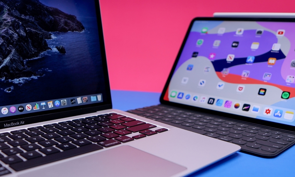 MacBook Air and iPad open on table with keyboards