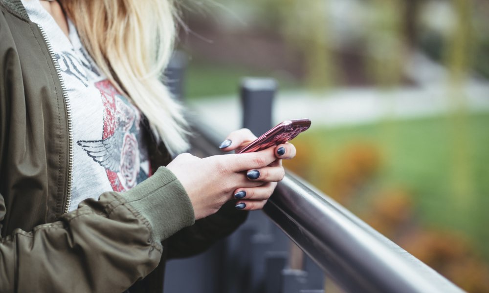 woman holding red iPhone